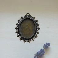 Fém medál alap 18*25mm ovál, "S" mintás-gyöngyös, bronz színű